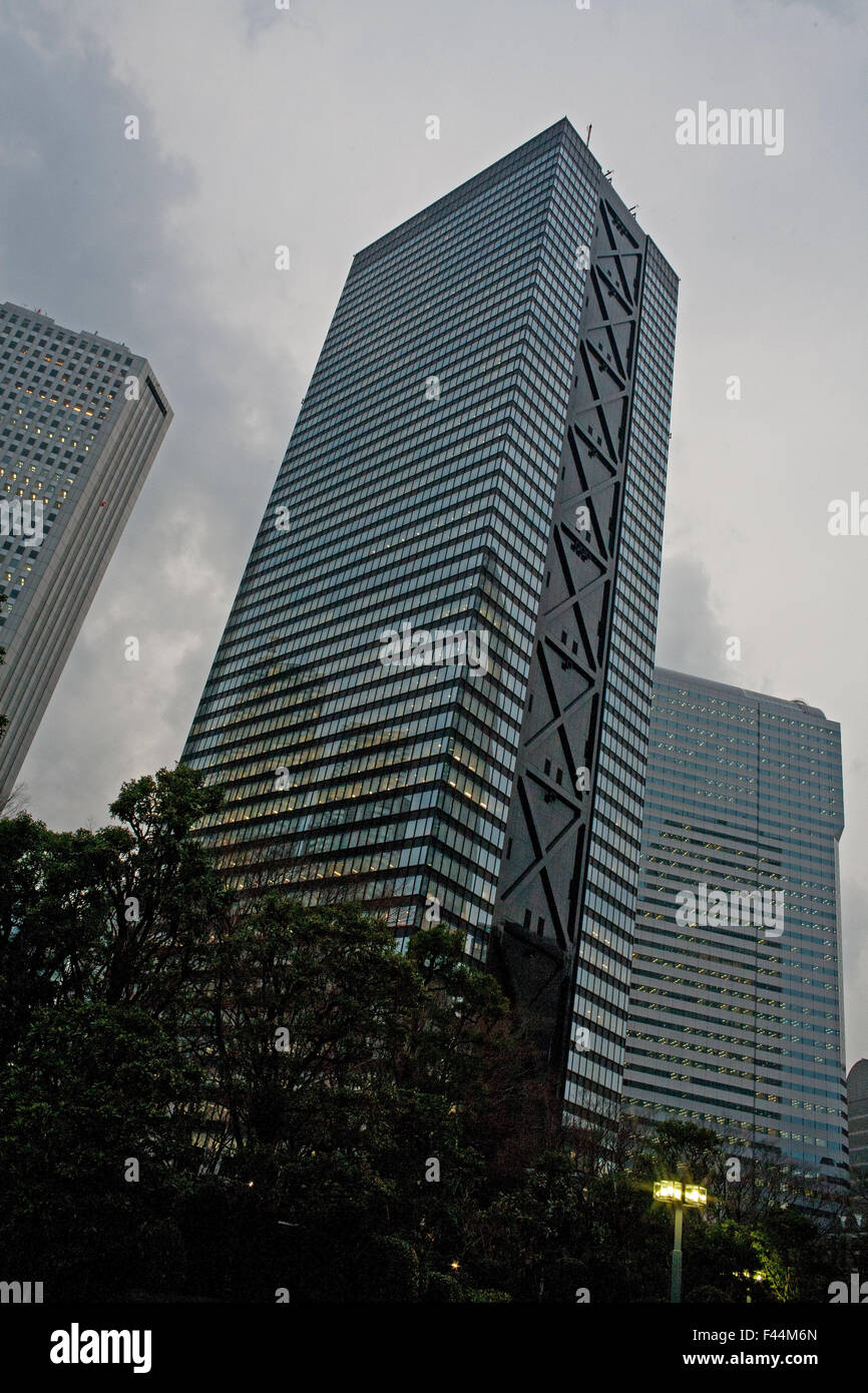 Glass and black metal office building with trees below later afternoon angled Stock Photo