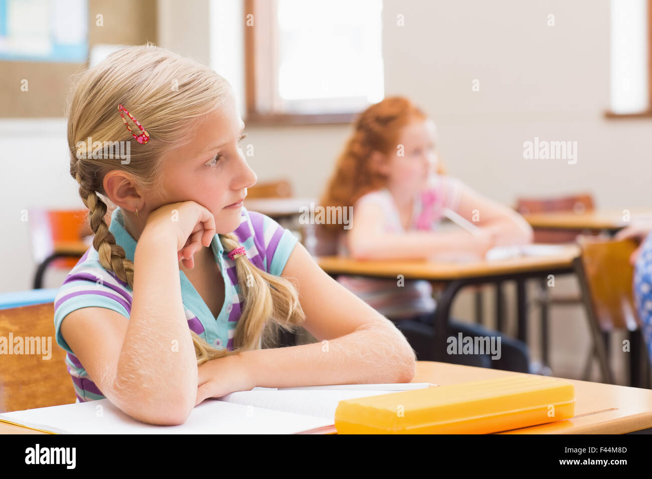 Thoughtful pupil sitting at her desk Stock Photo - Alamy
