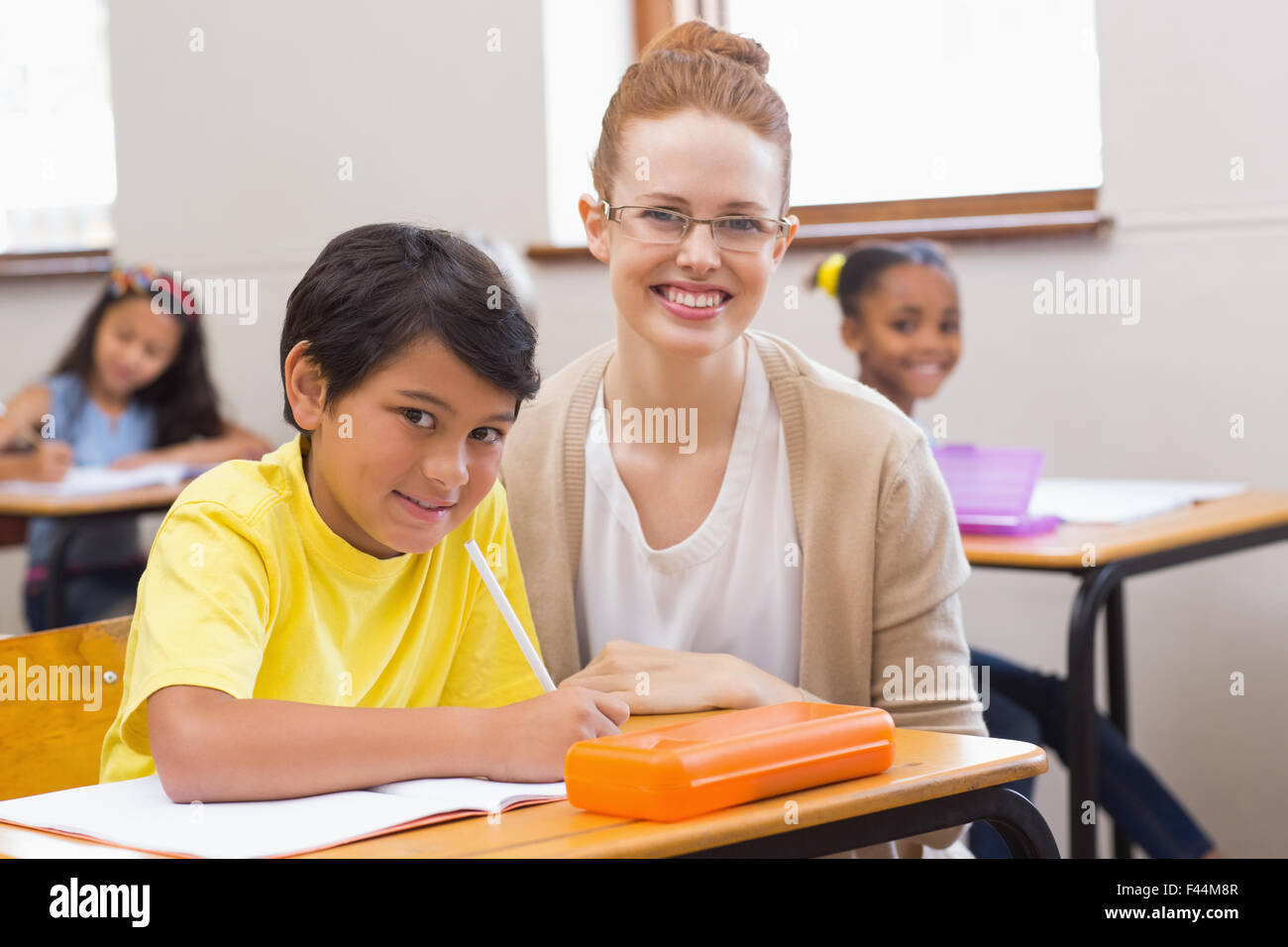Teacher and pupil smiling at camera Stock Photo - Alamy
