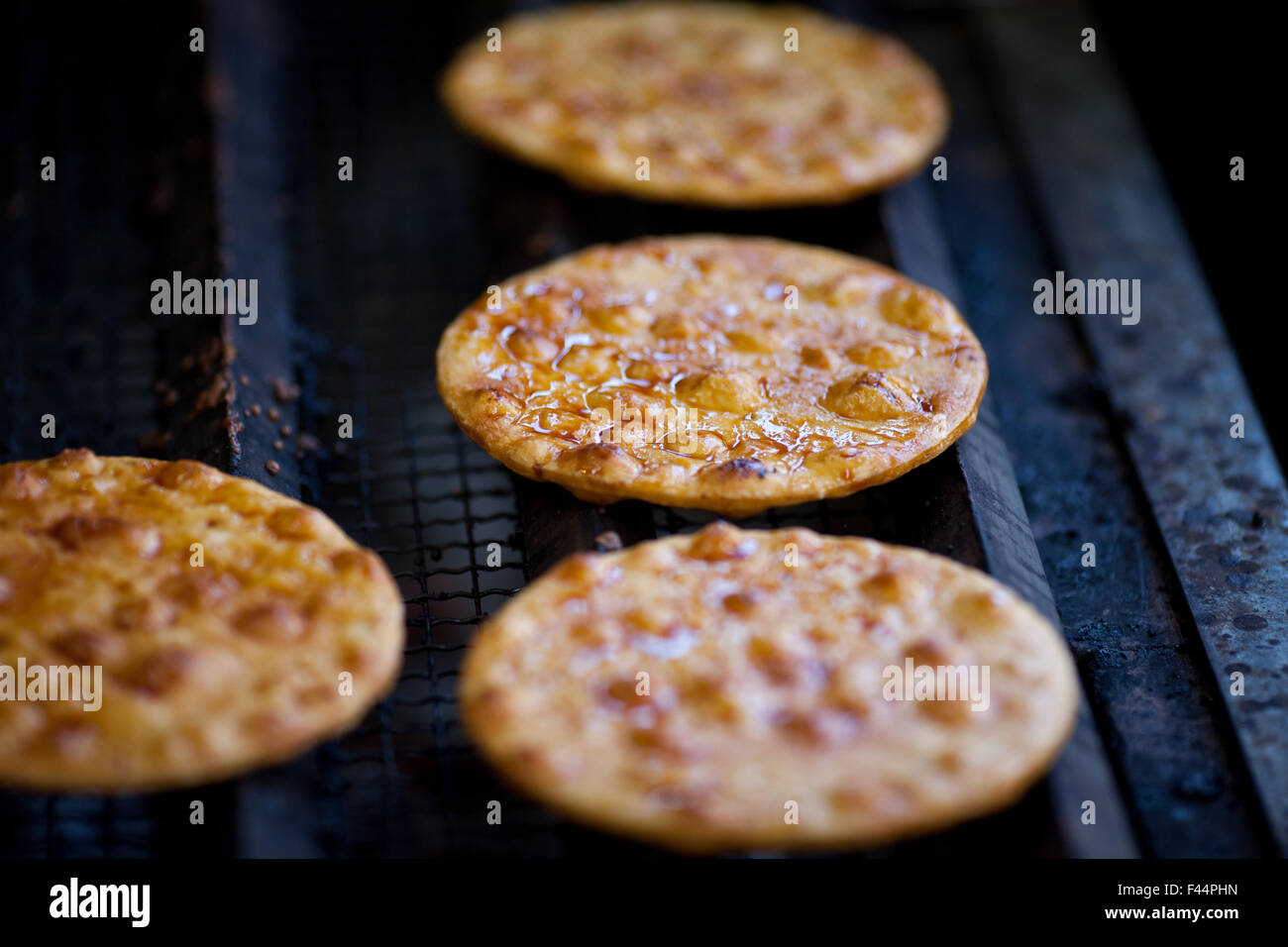 Japanese rice cracker cooking on grill with soy sauce glaze Stock Photo