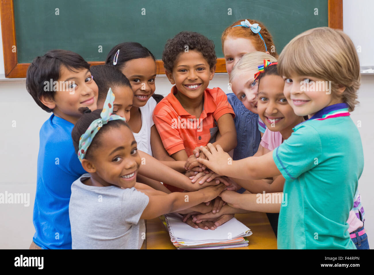 Cute pupils smiling at camera in classroom Stock Photo - Alamy