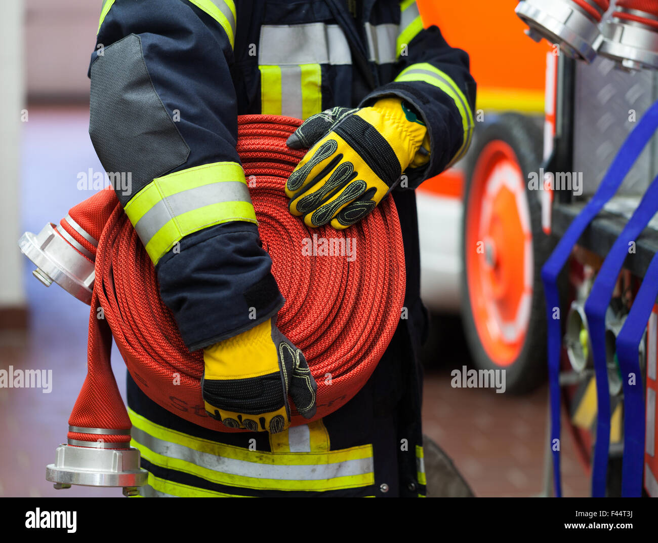 Fireman in action with water hose Stock Photo - Alamy