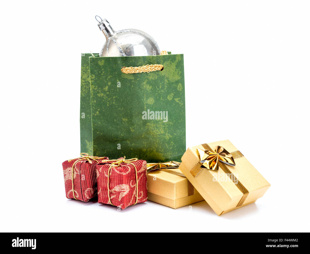 Green paper christmas shopping bag with silver christmas ball and present boxes shot on white background Stock Photo