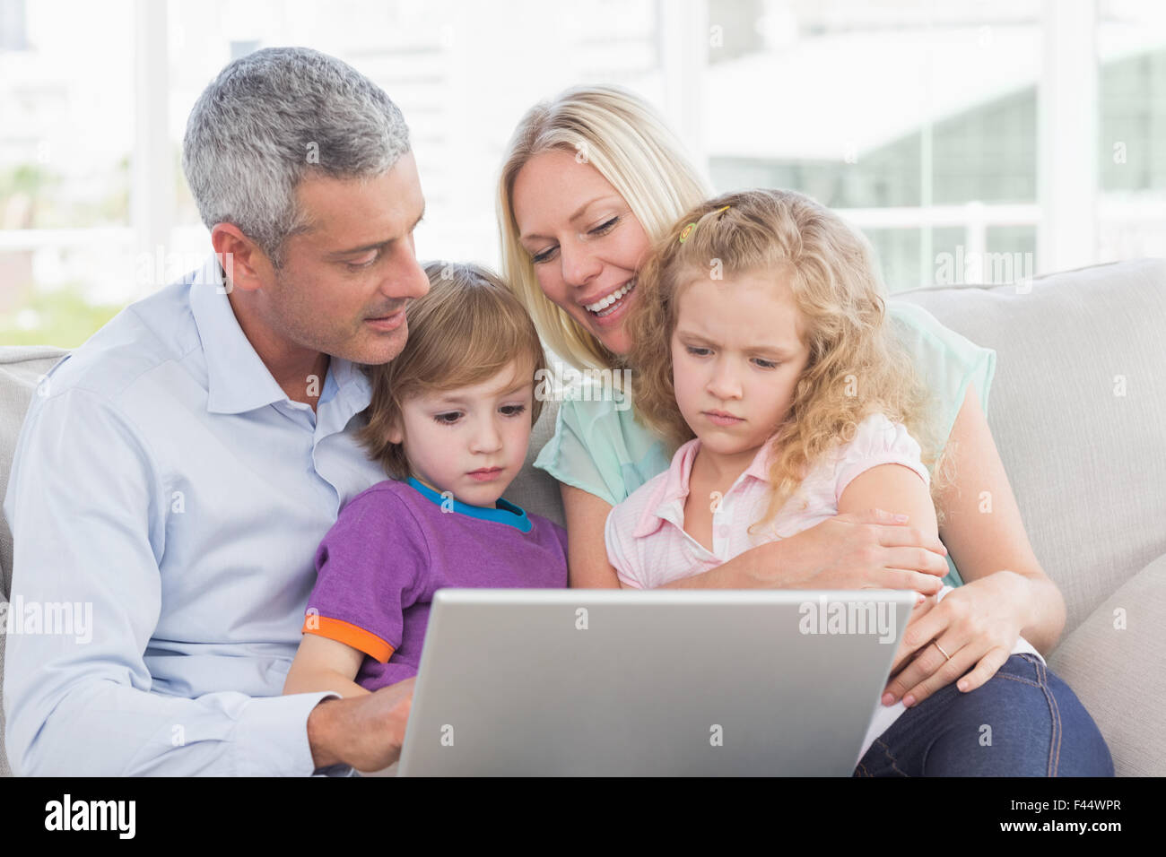 Parents using laptop with children Stock Photo Alamy