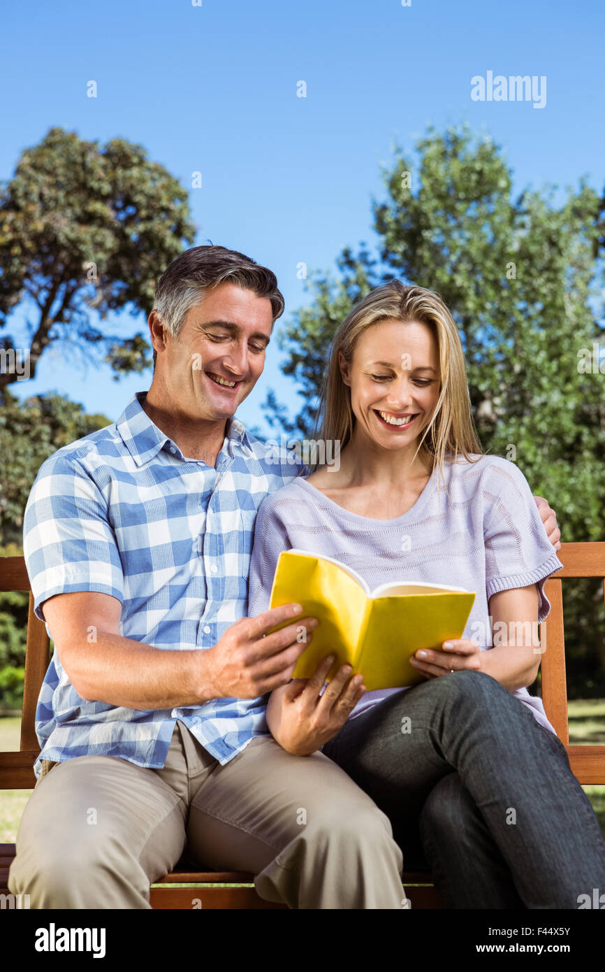 Couple relaxing in the park on bench Stock Photo - Alamy