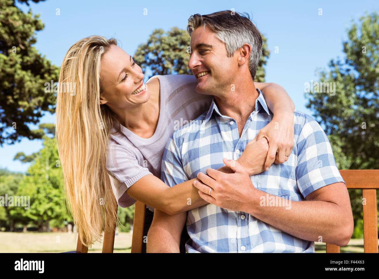 Couple relaxing in the park on bench Stock Photo - Alamy