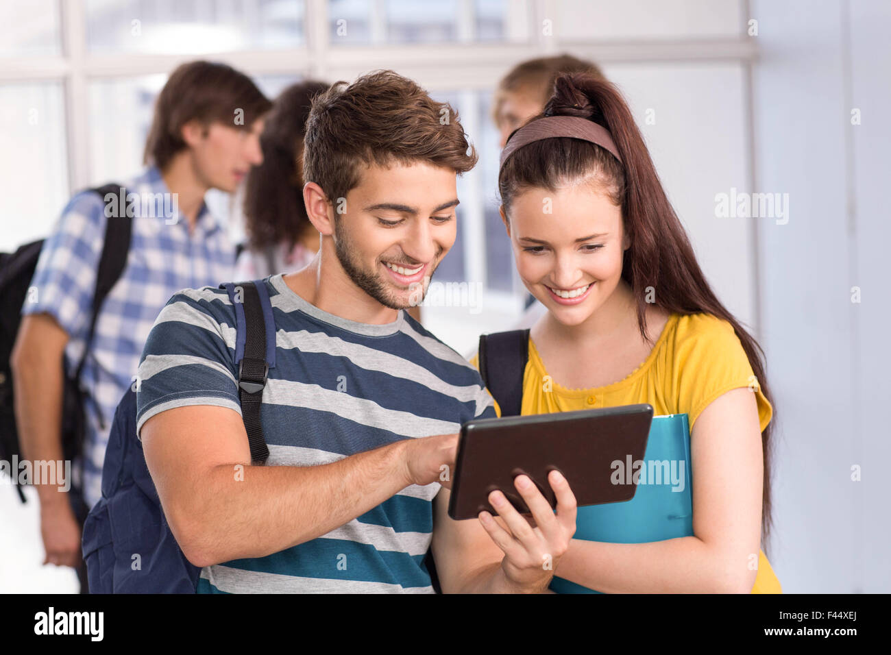 Smiling students using digital tablet Stock Photo - Alamy