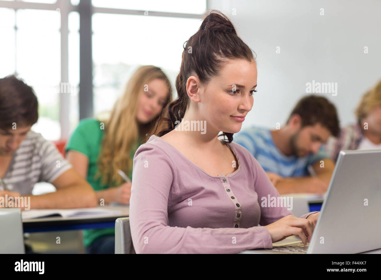 Female student using laptop in classroom Stock Photo - Alamy
