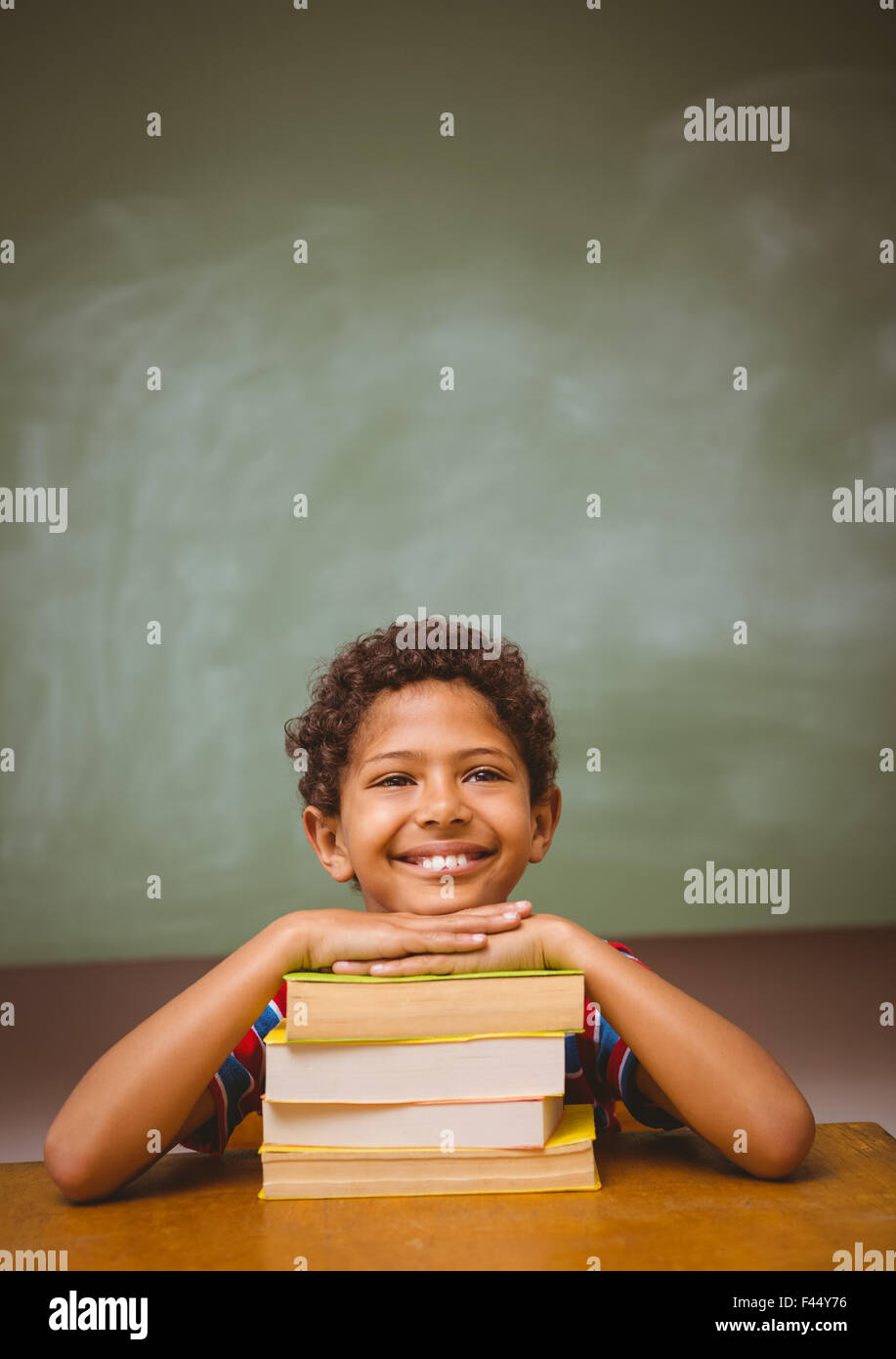 Little boy with stack of books in classroom Stock Photo - Alamy
