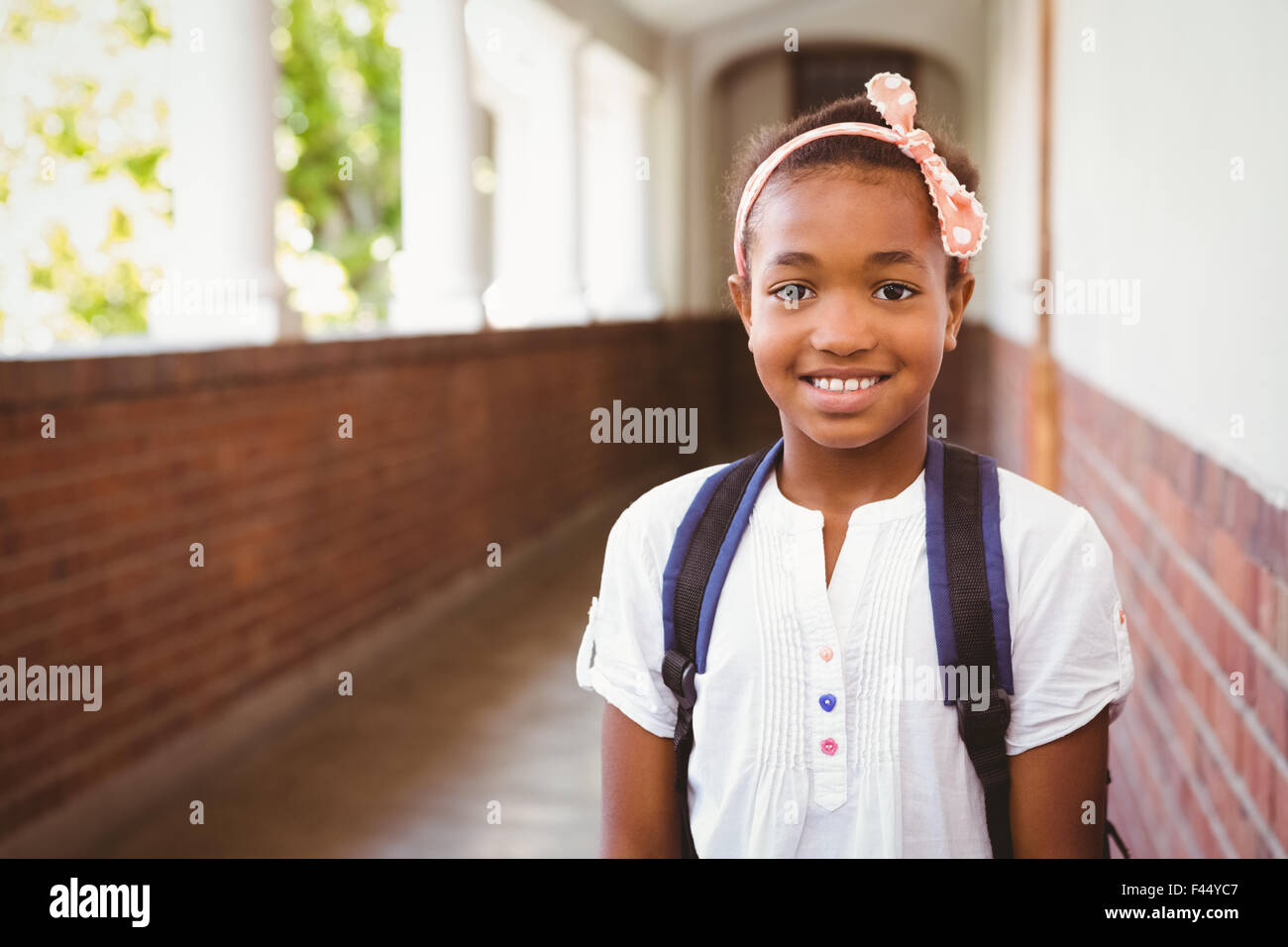 Little girl smiling in school corridor Stock Photo - Alamy