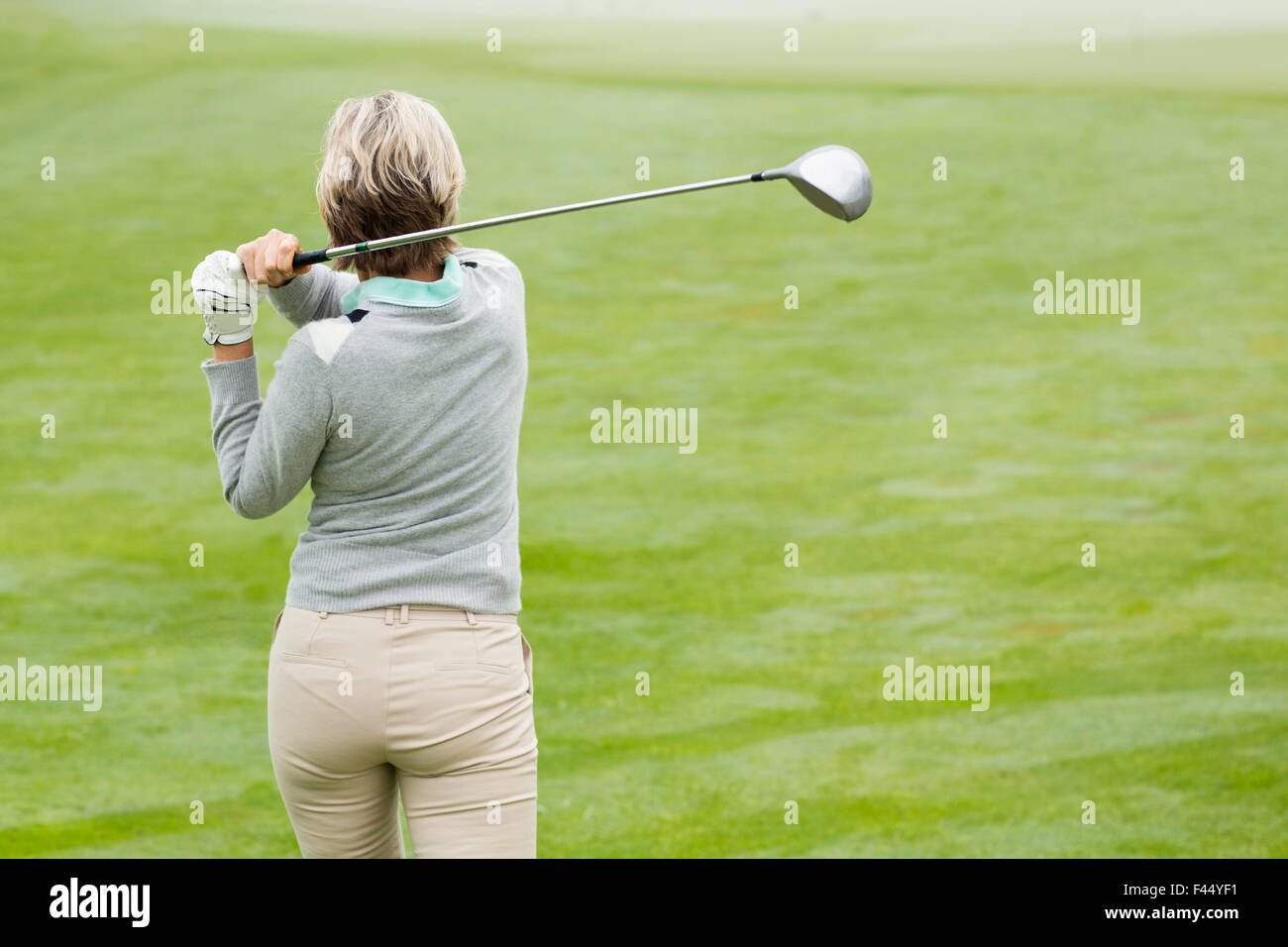 Lady golfer teeing off for the day Stock Photo