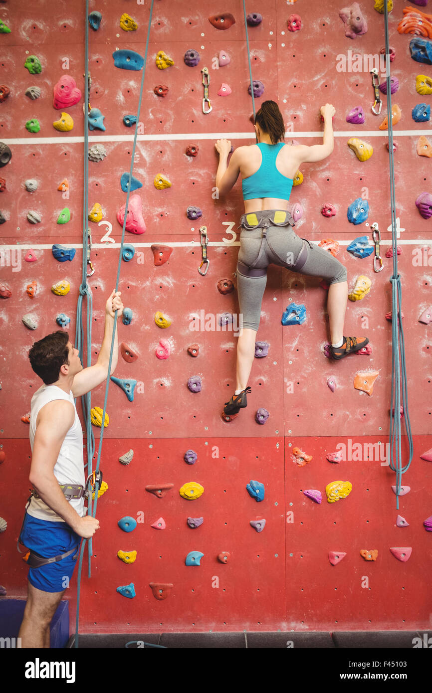 Instructor guiding woman on rock climbing wall Stock Photo Alamy