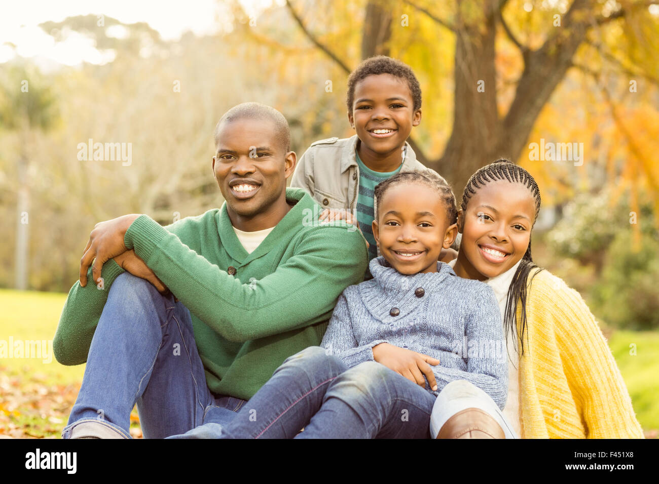 Portrait of a young family sitting in leaves Stock Photo