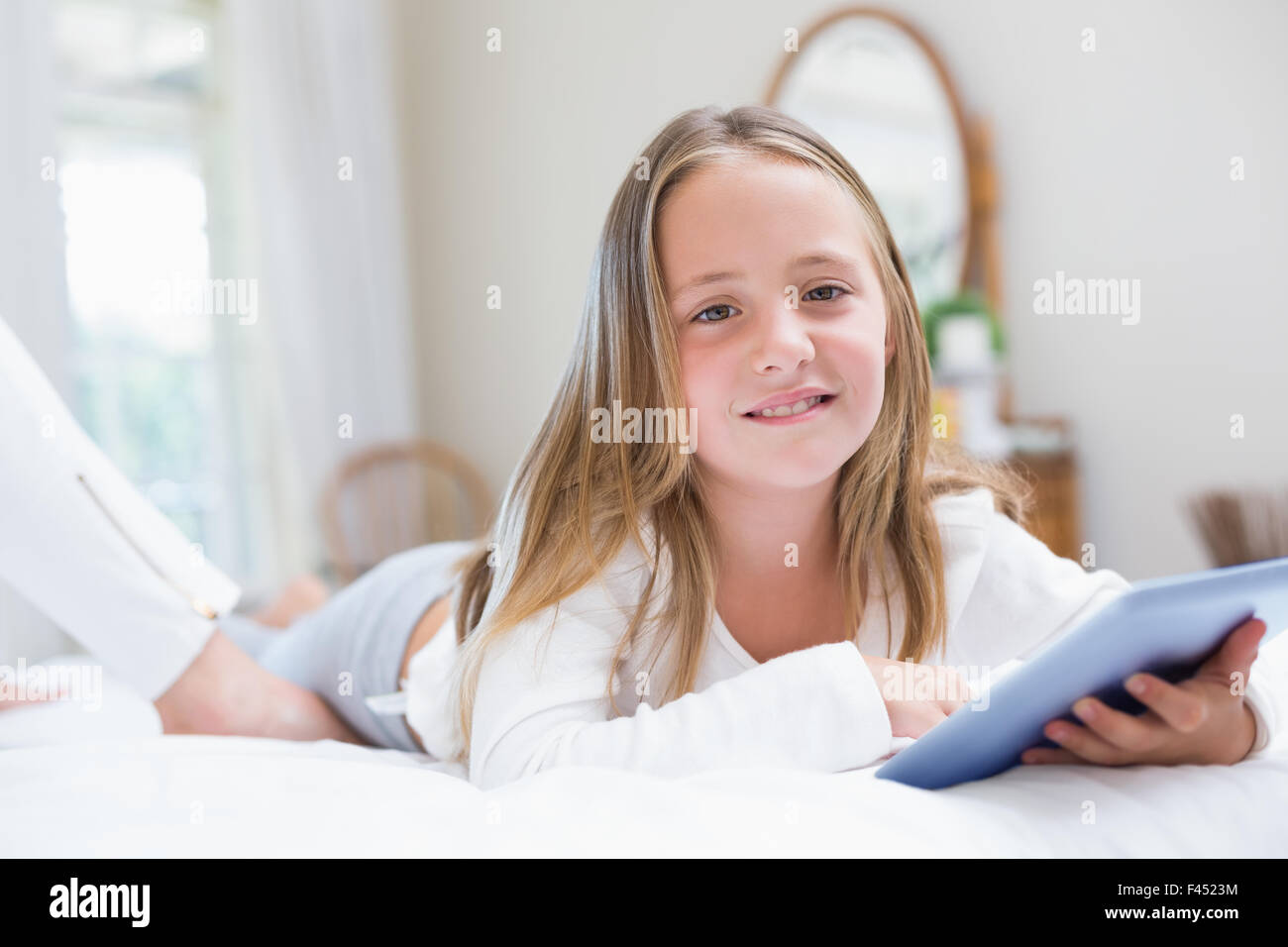 Little girl using tablet pc in the bed Stock Photo - Alamy
