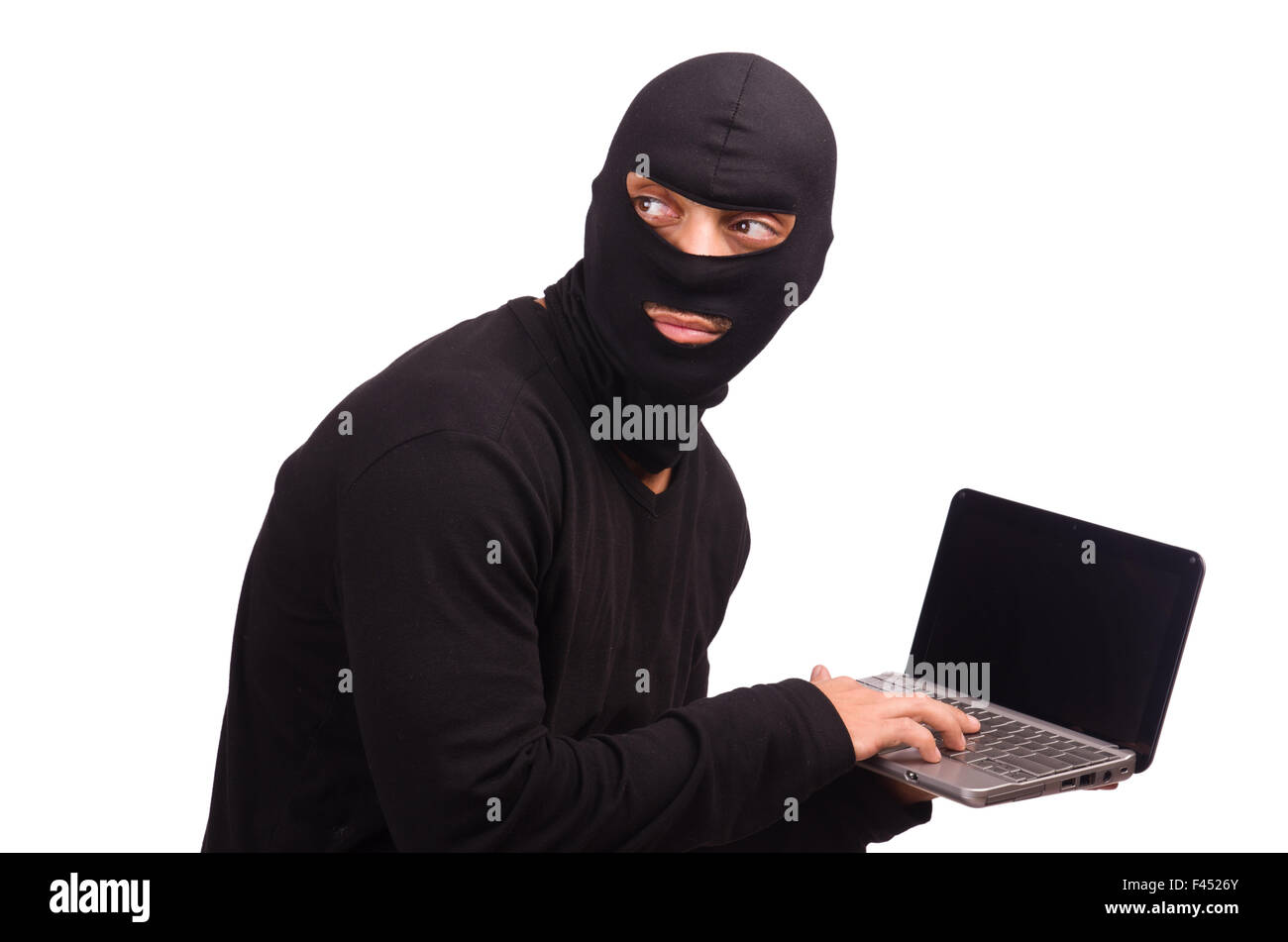 Hacker with computer wearing balaclava Stock Photo - Alamy