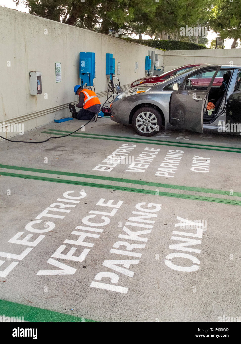 Repair technicians maintain an electric car charging station at an