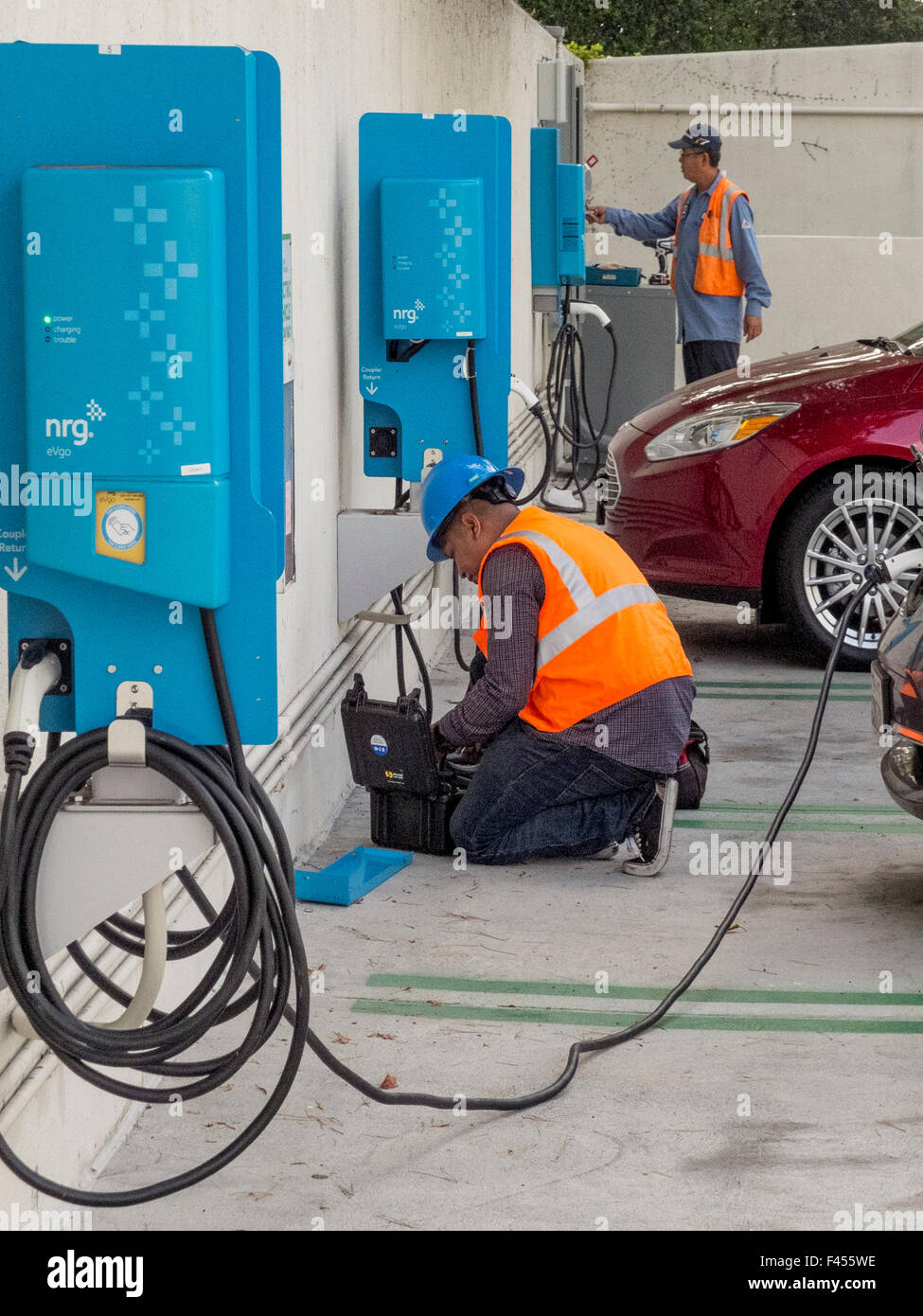 Repair technician maintains an electric car charging station at an