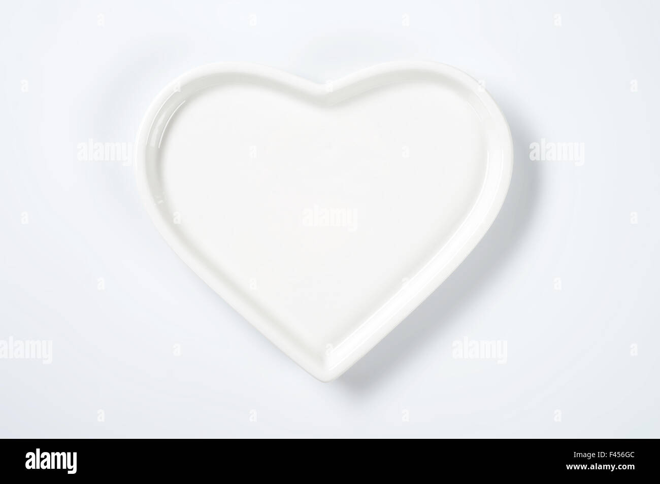 white heart shaped plate on white background Stock Photo - Alamy