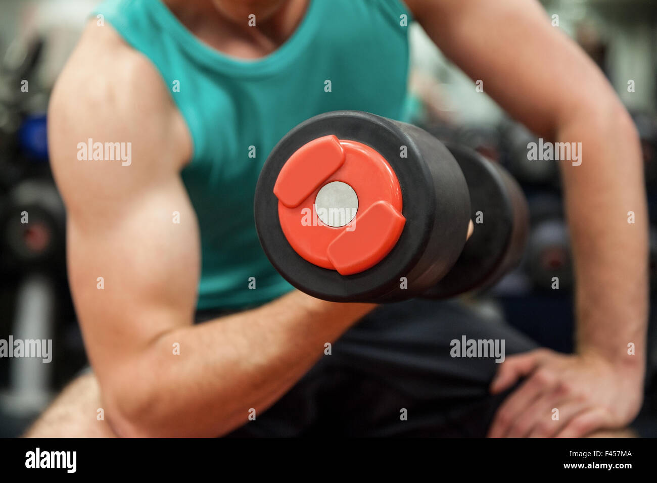 Man lifting dumbbell weight while sitting Stock Photo Alamy