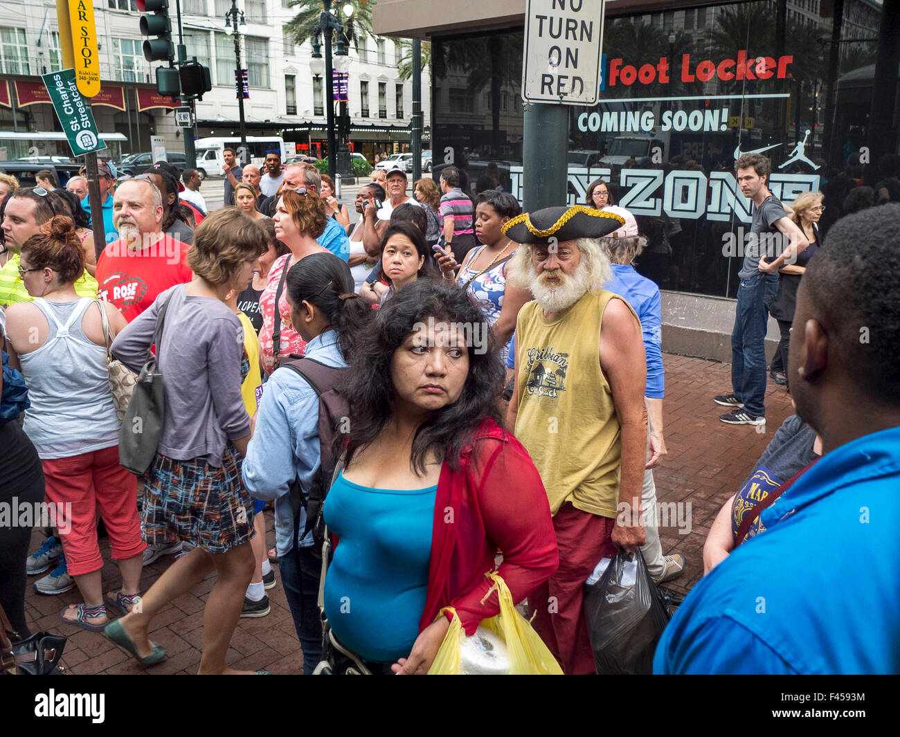 An eclectic multiracial crowd waits for a trolley on Canal Street in