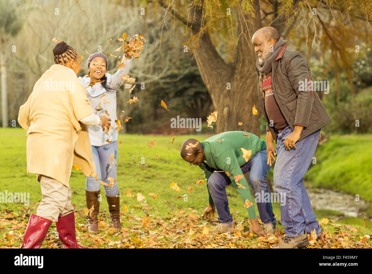 Happy family throwing leaves around Stock Photo