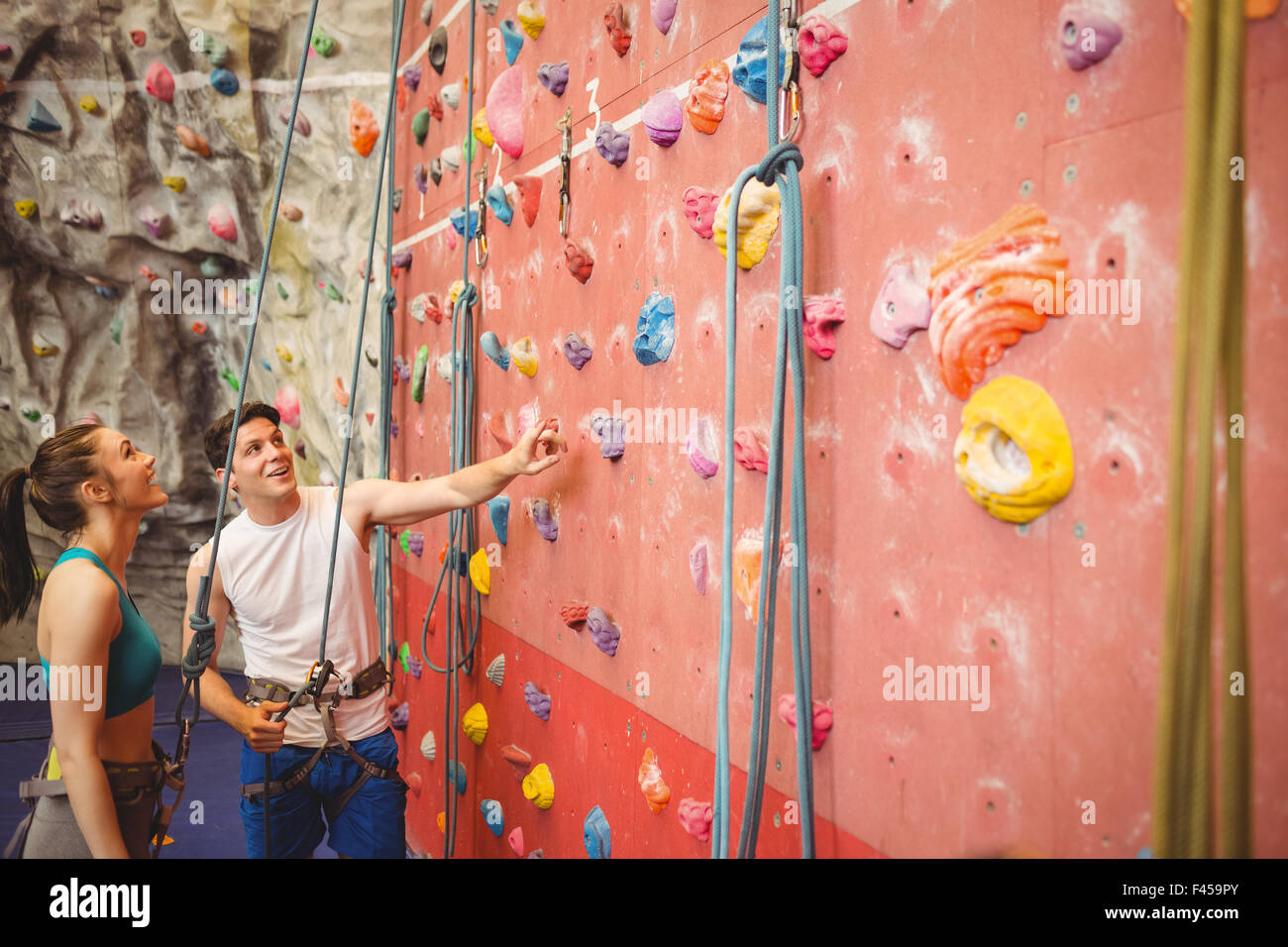Instructor showing woman rock climbing wall Stock Photo Alamy