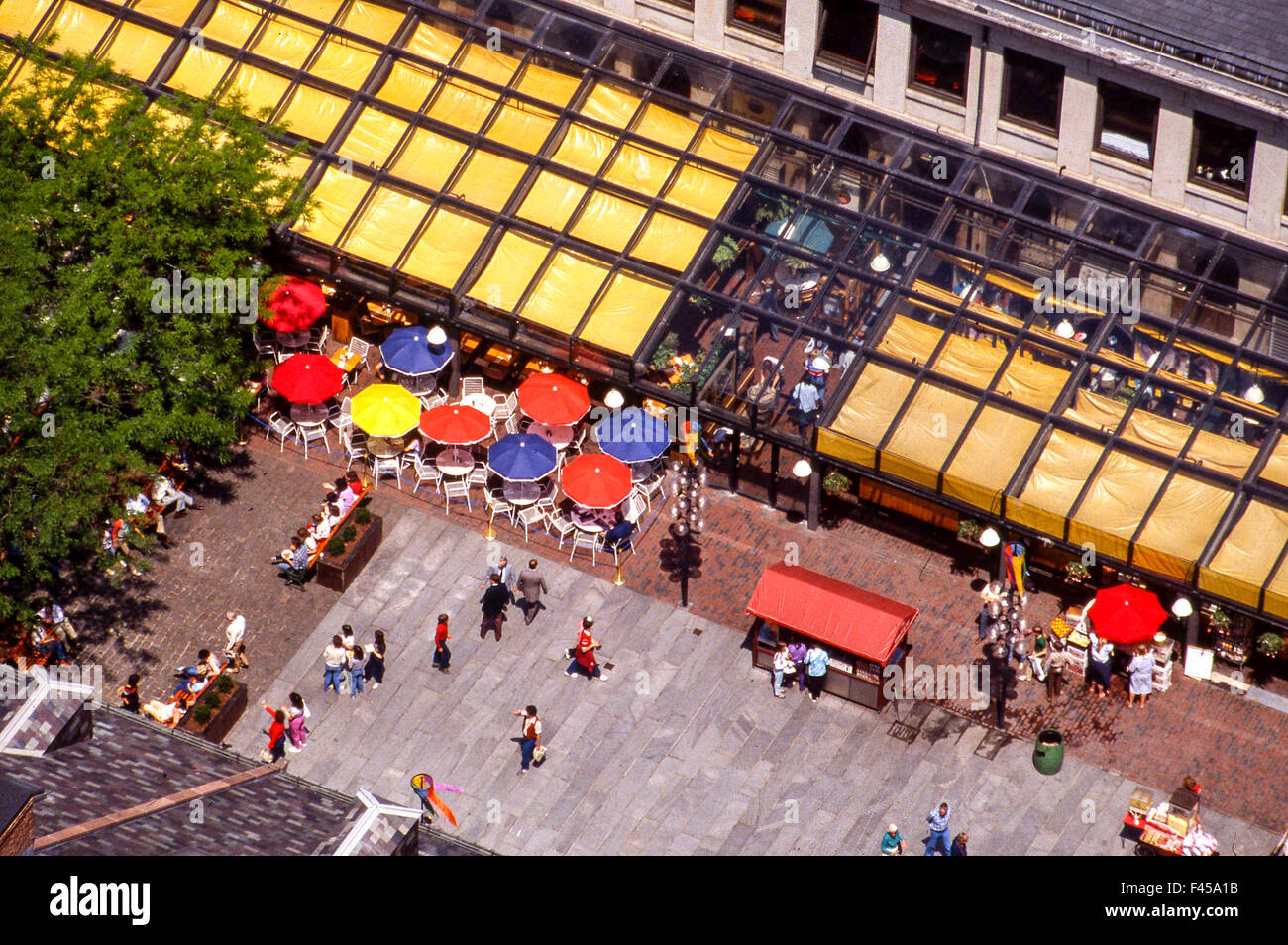 Lunchtime diners gather under outdoor umbrellas at Boston's famous Quincy Market, part of Faneuil Hall Marketplace. Stock Photo