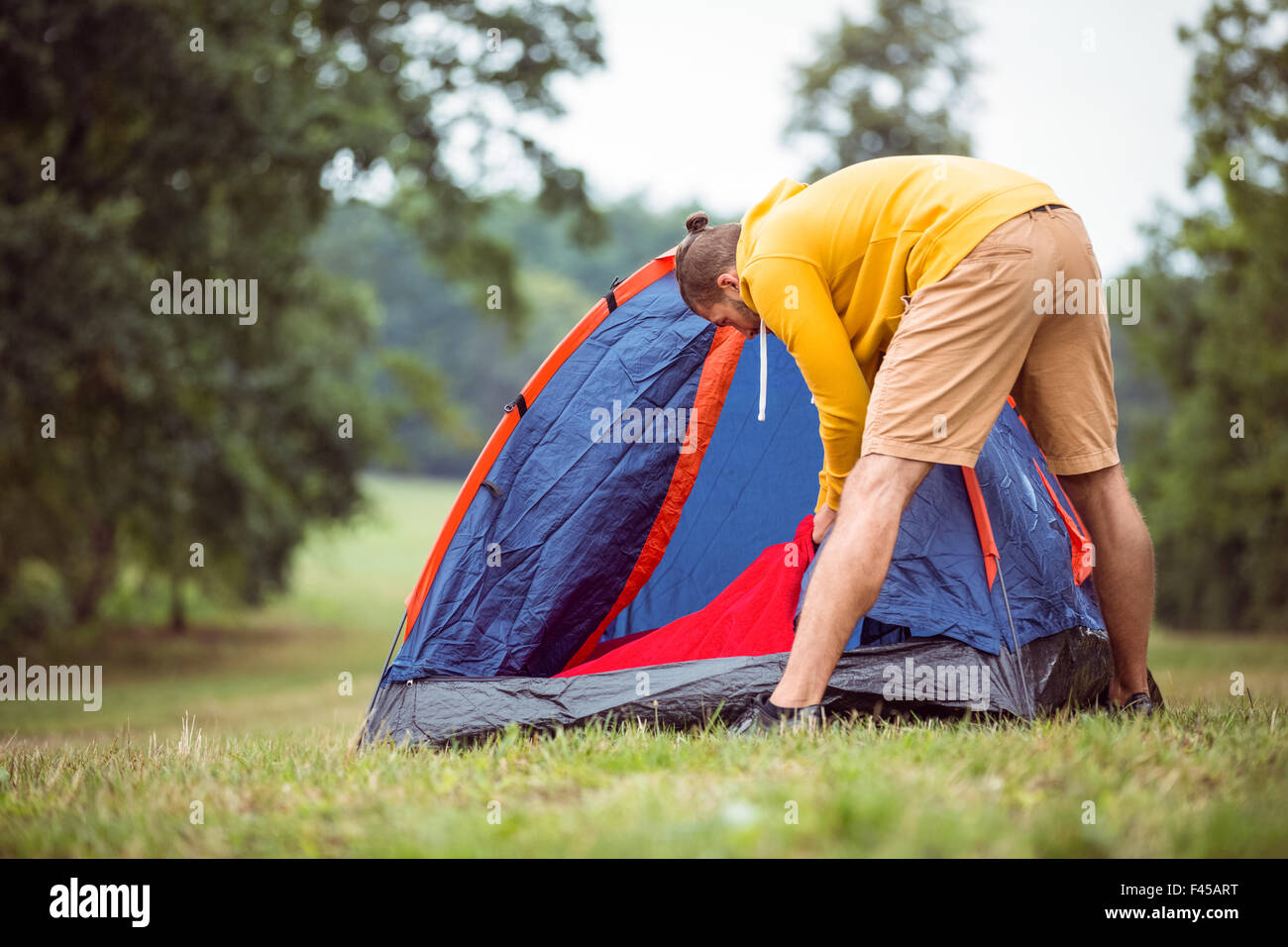 Handsome hipster pitching his tent Stock Photo