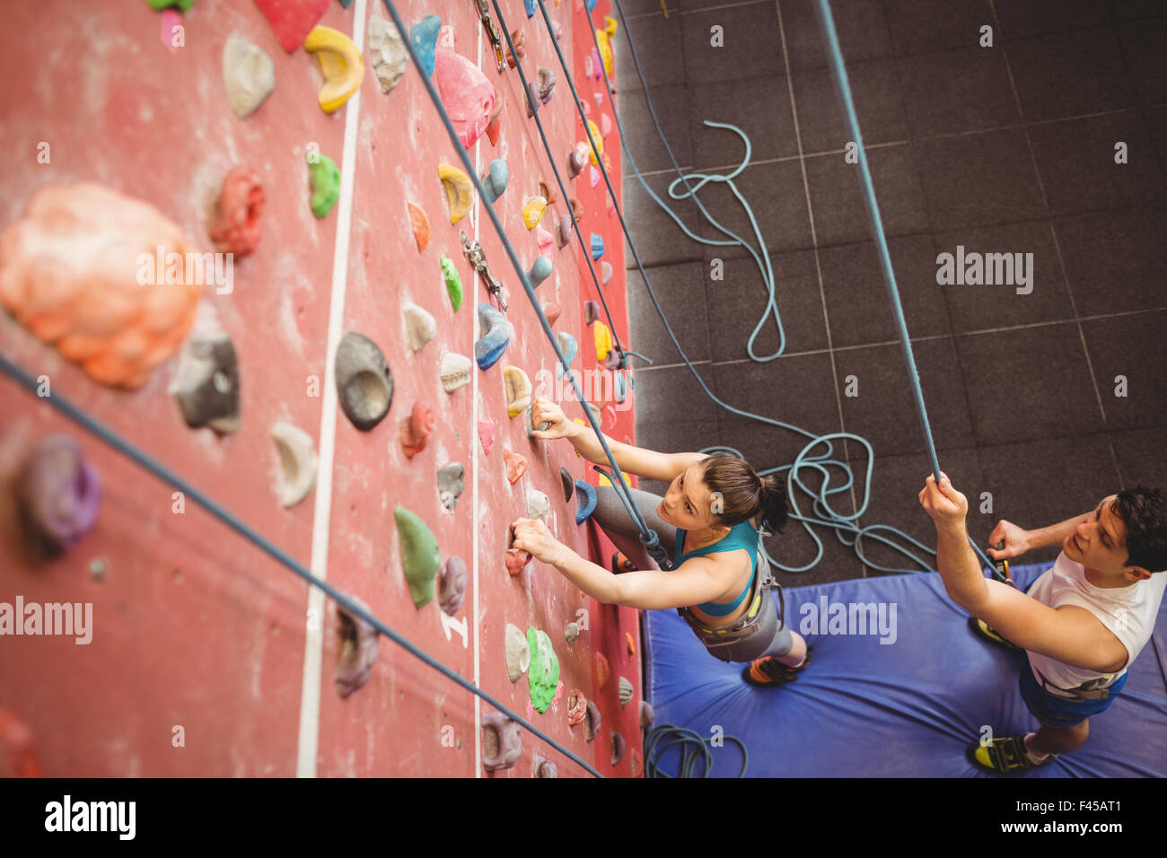 Instructor guiding woman on rock climbing wall Stock Photo Alamy