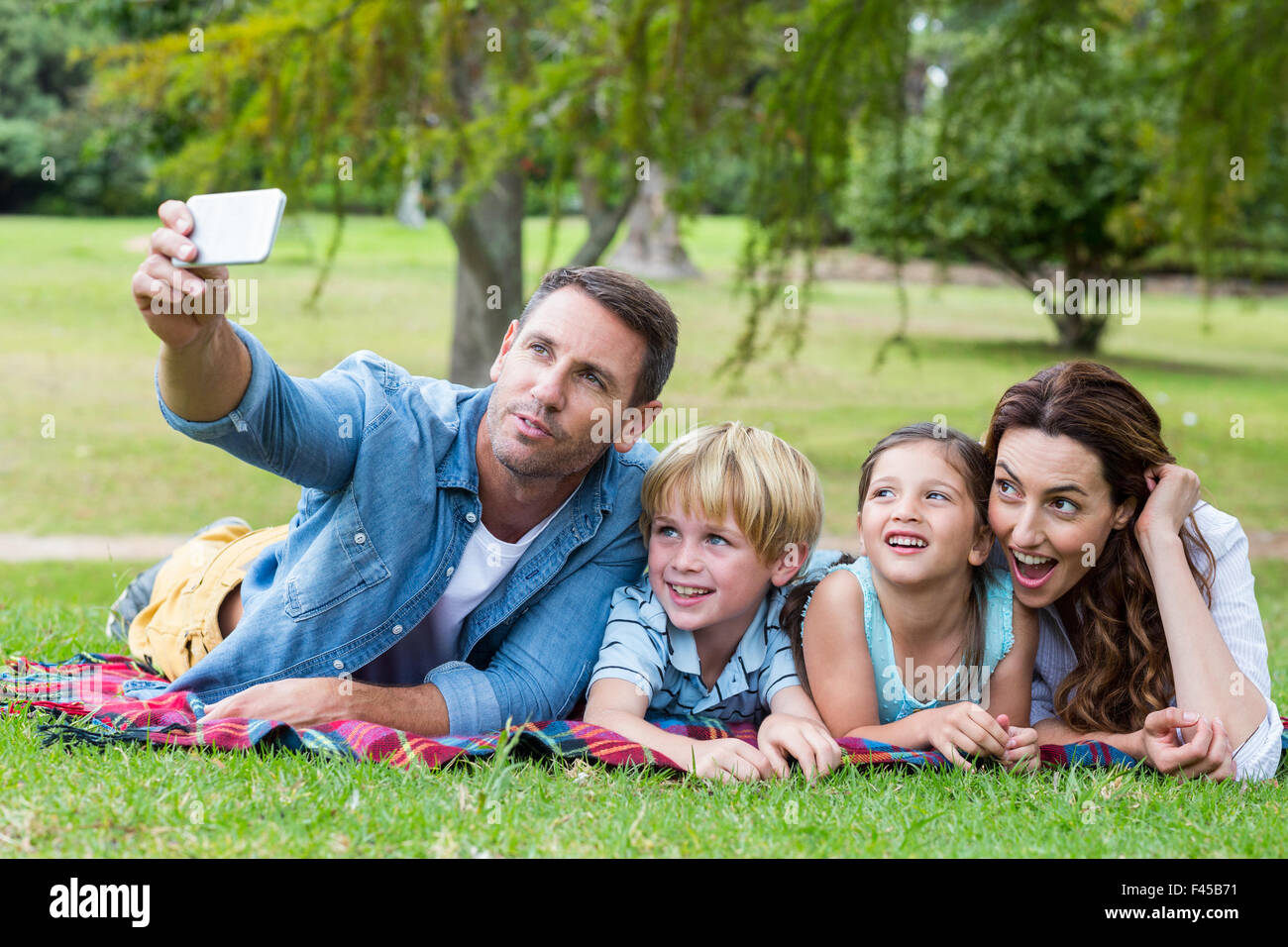 Happy family in the park taking selfie Stock Photo - Alamy