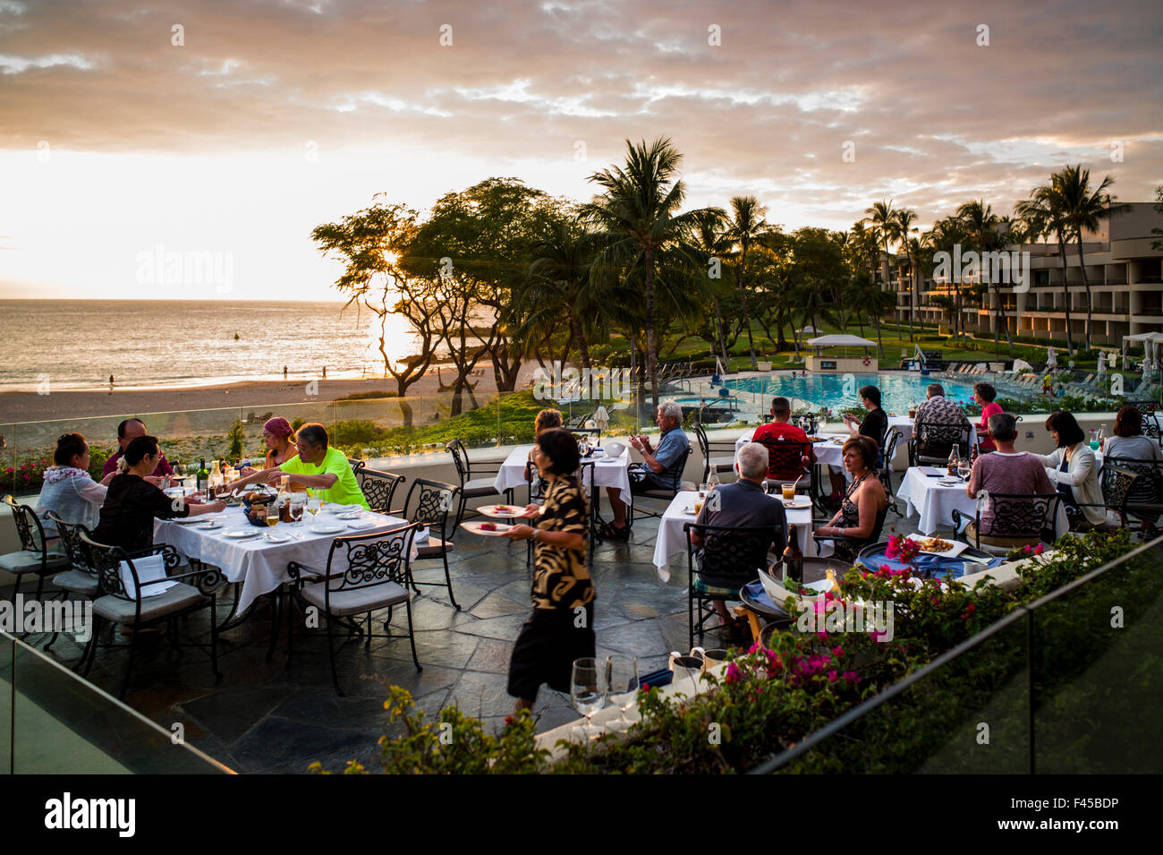 Tourists dine at sunset, Coast Grill, Hapuna Beach Prince Hotel & Golf Course, w beach & ocean beyond, Kohala Coast, Hawai'i USA Stock Photo
