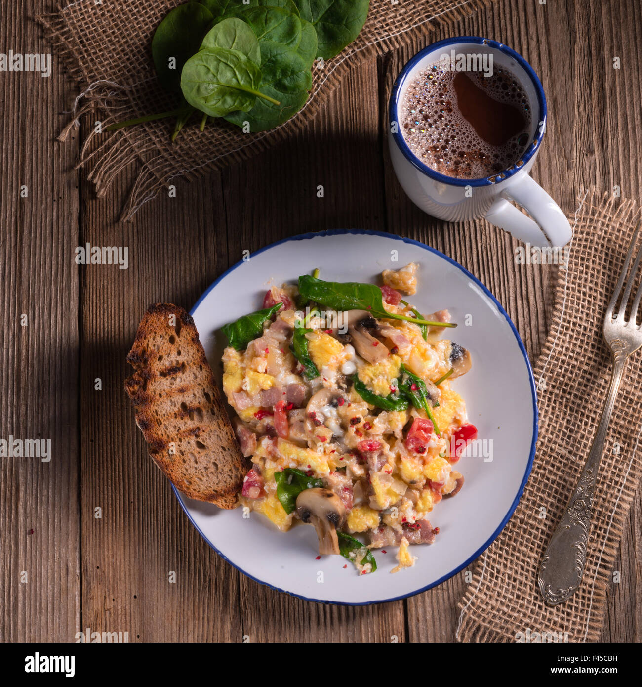 Scrambled eggs with tomatoes and spinach Stock Photo - Alamy