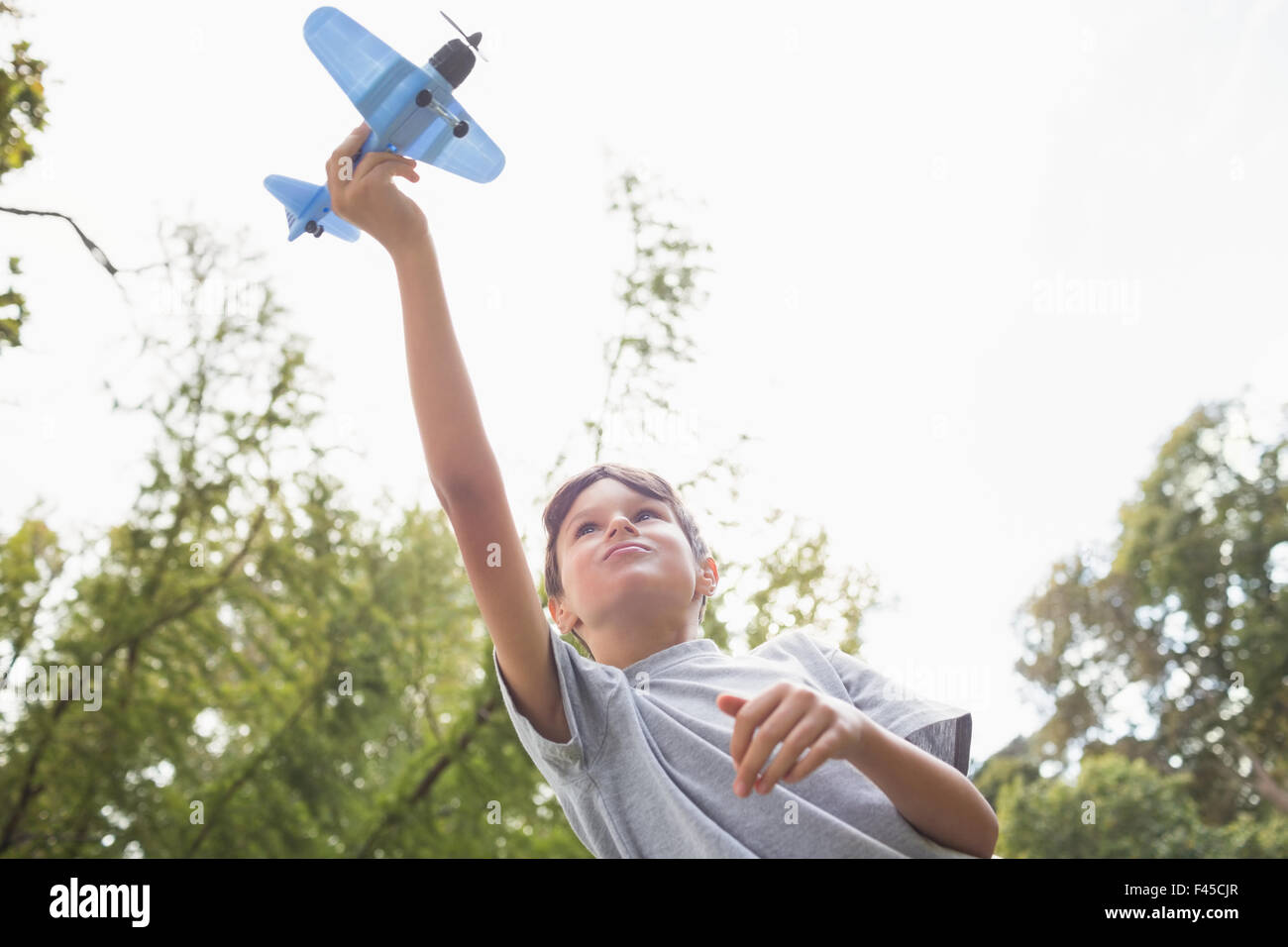Boy playing with a toy plane at park Stock Photo - Alamy