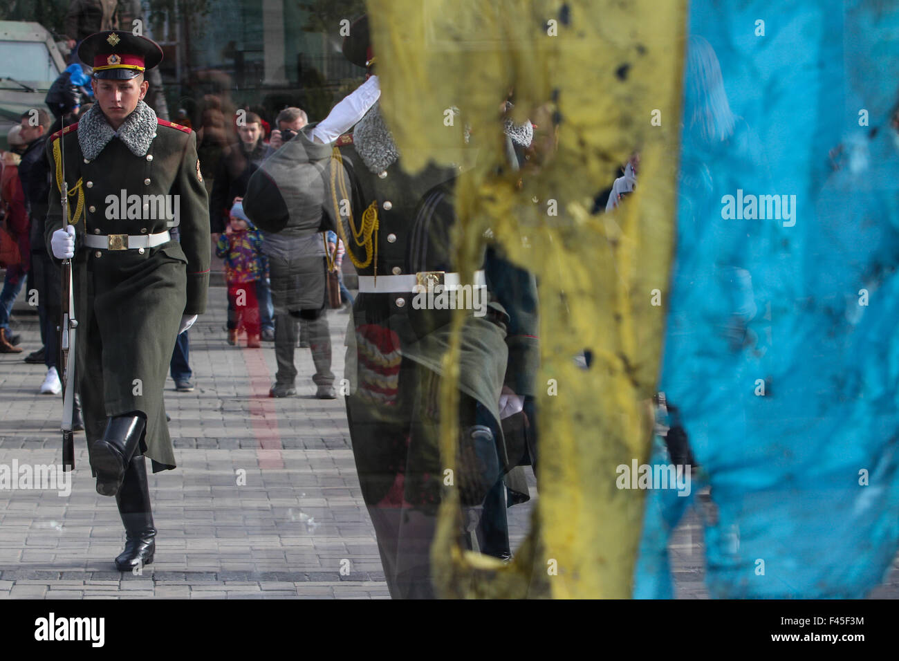 Ukraine. 14th Oct, 2015. People look at a Ukrainian flag that survived in Ilovaysk battle on Mykhailivska square. The flag was unfolded at UNGA as Putin was speaking. © Sergii Kharchenko/Pacific Press/Alamy Live News Stock Photo