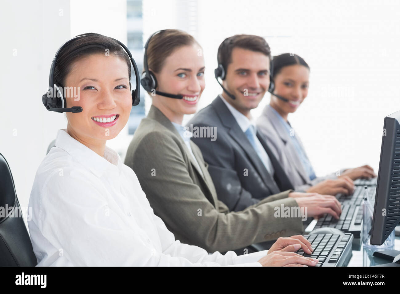 Business people with headsets using computers Stock Photo - Alamy
