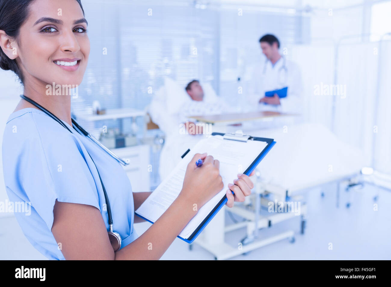 Smiling doctor checking patients file Stock Photo - Alamy