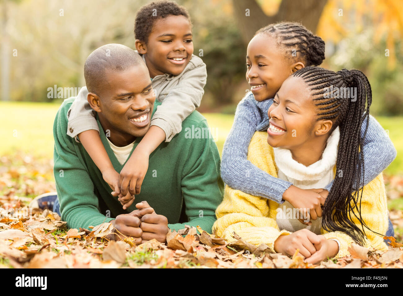 Portrait of a young family lying in leaves Stock Photo