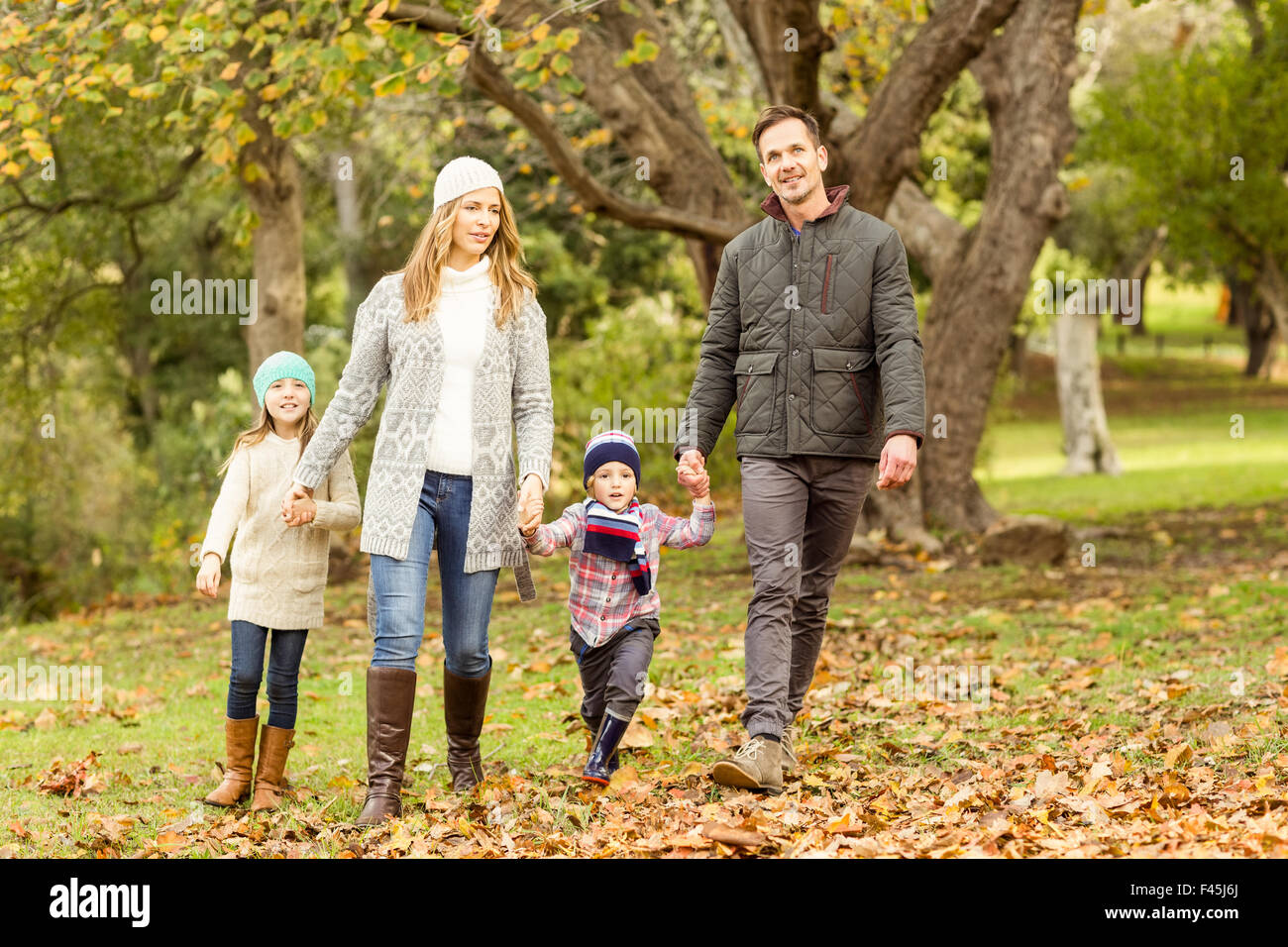 Young family running in leaves Stock Photo