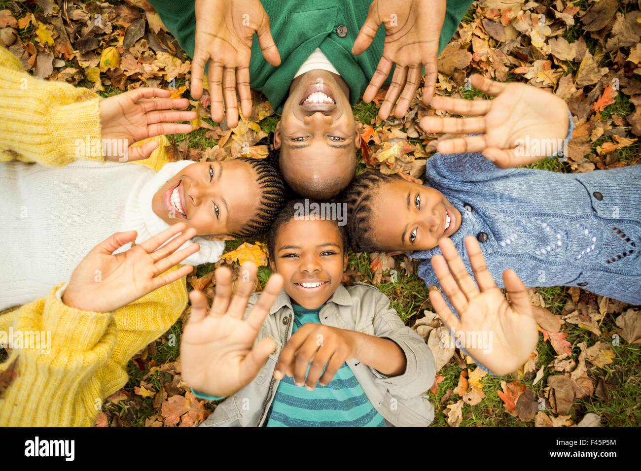 Young family doing a head circles and raising their hands Stock Photo