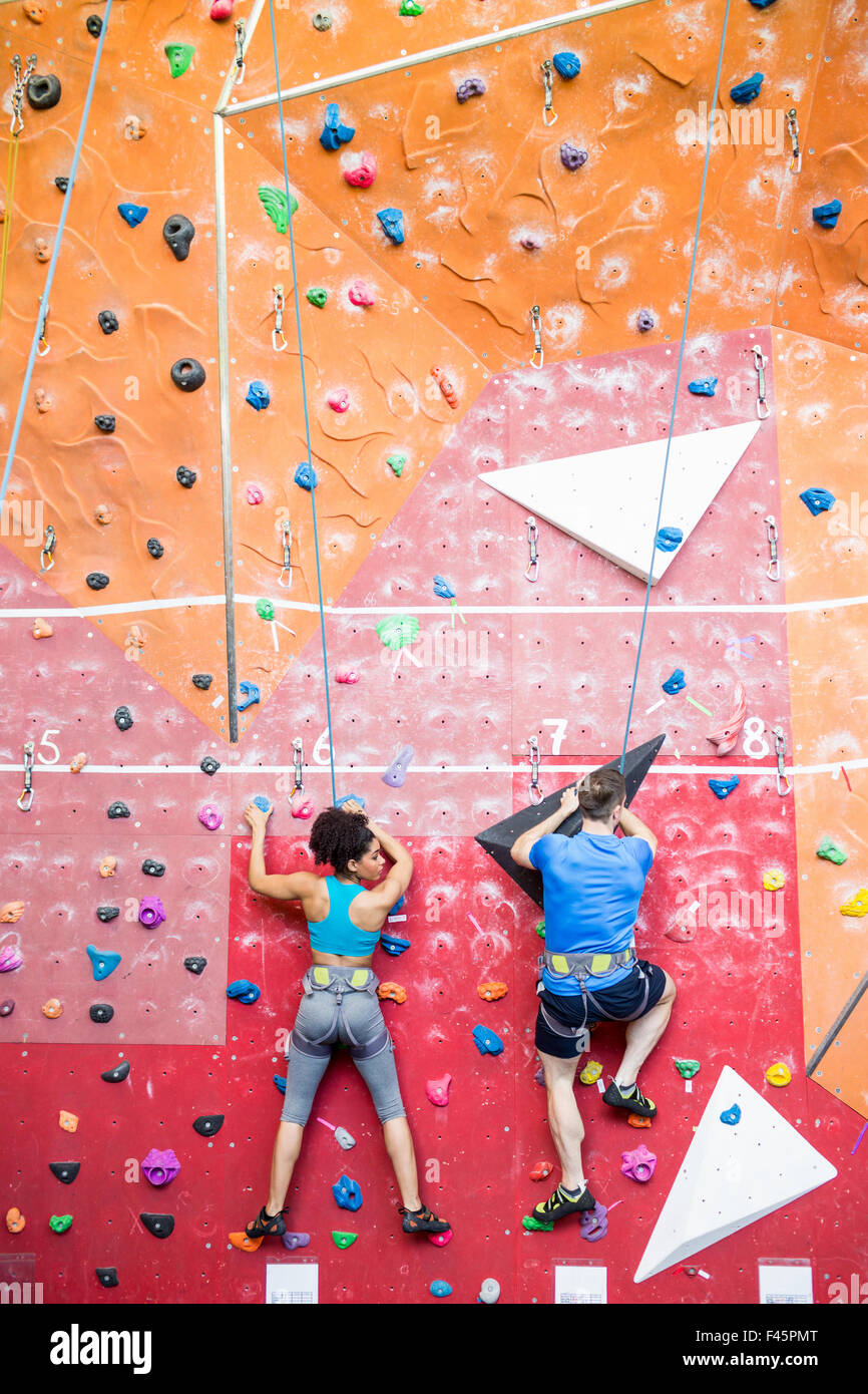 Fit couple rock climbing indoors Stock Photo