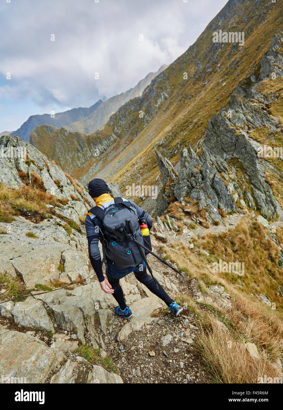 Caucasian man with backpack hiking into the mountains Stock Photo - Alamy