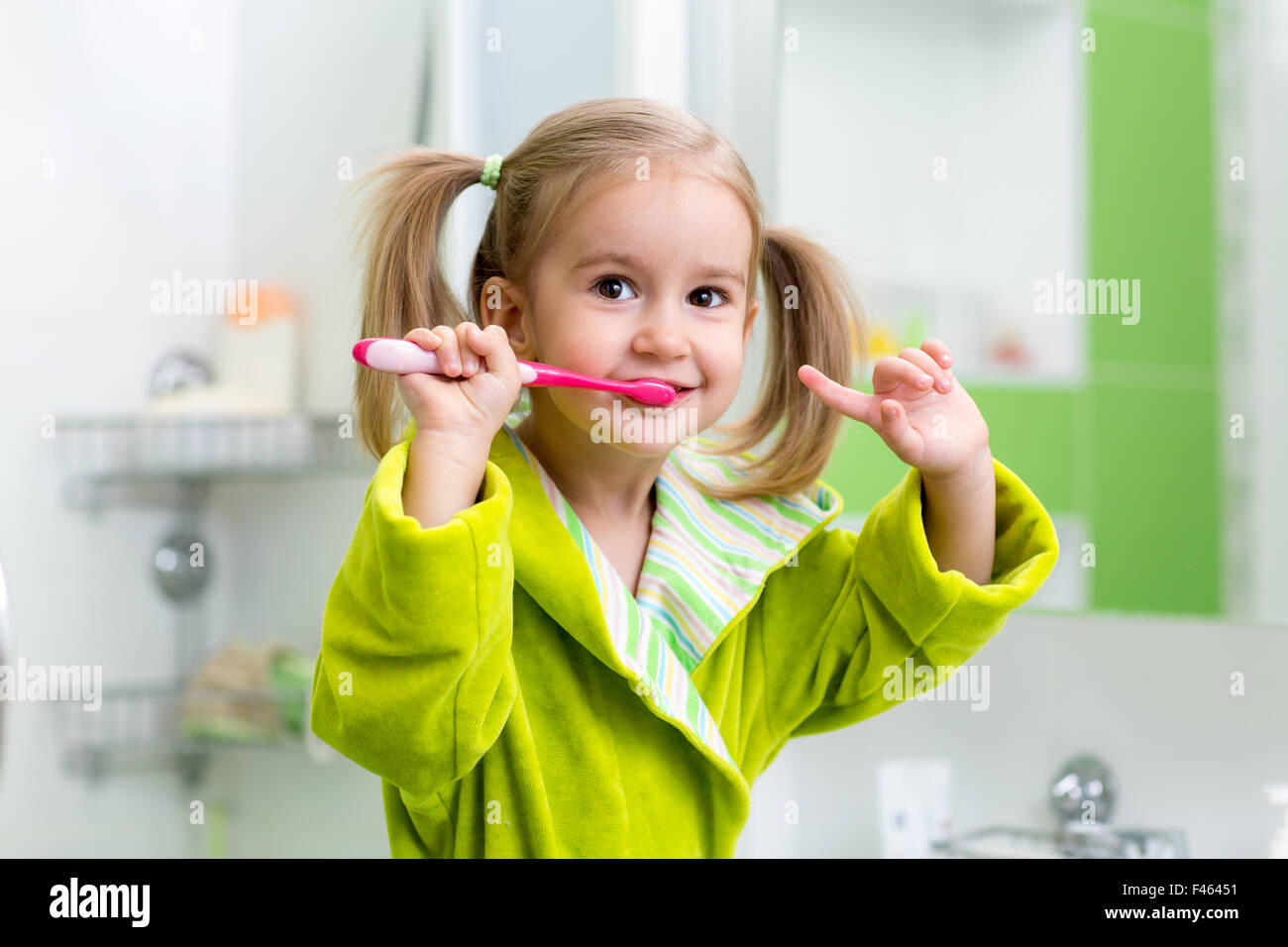 kid girl brushing teeth in bathroom Stock Photo