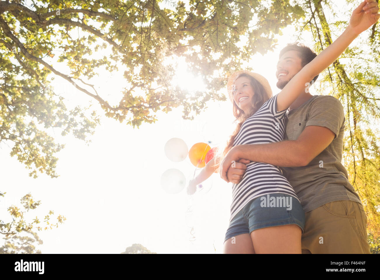 Cute couple hugging and holding balloons in the park Stock Photo - Alamy