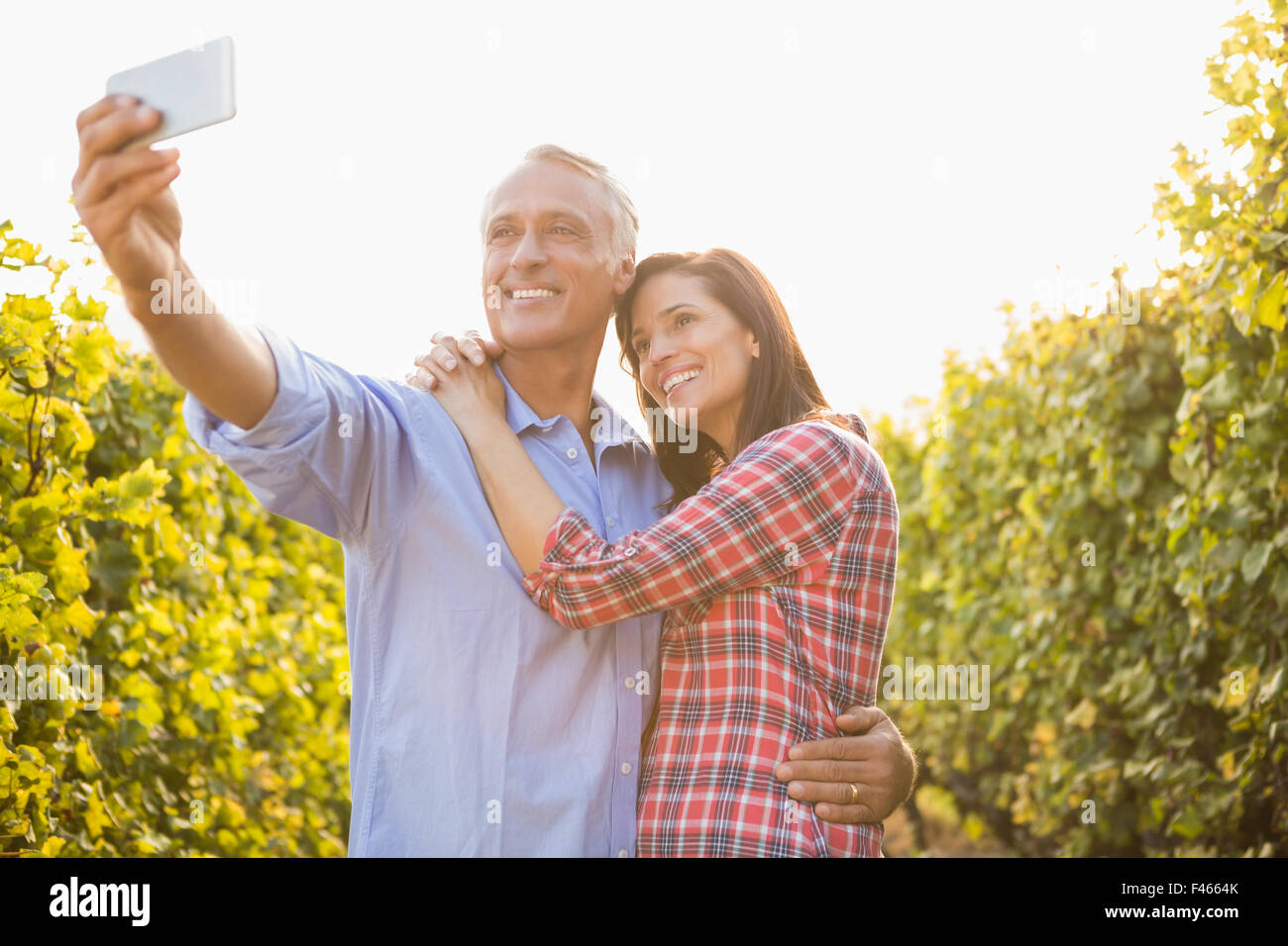Happy couple embracing and taking selfies Stock Photo