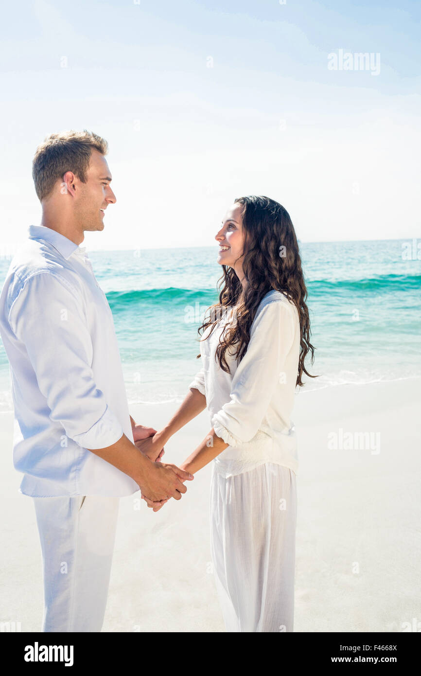 Couple holding hands and standing at beach Stock Photo - Alamy