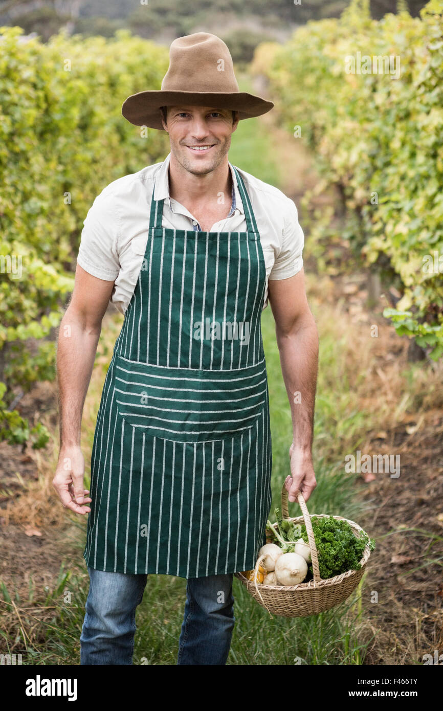 Young happy farmer holding a basket of vegetables Stock Photo - Alamy