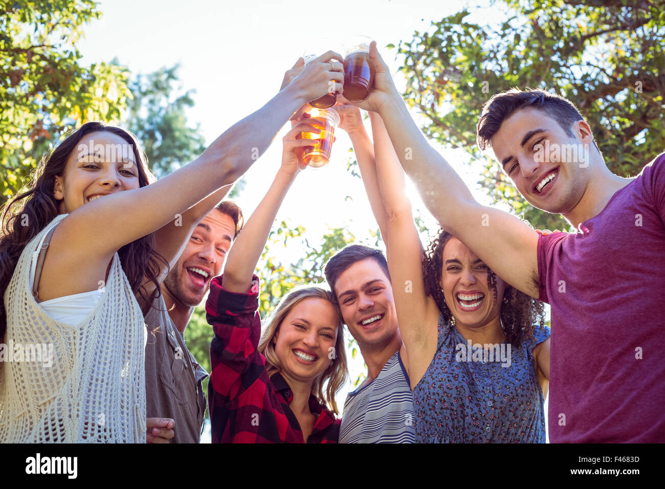 Happy friends in the park having beers Stock Photo - Alamy