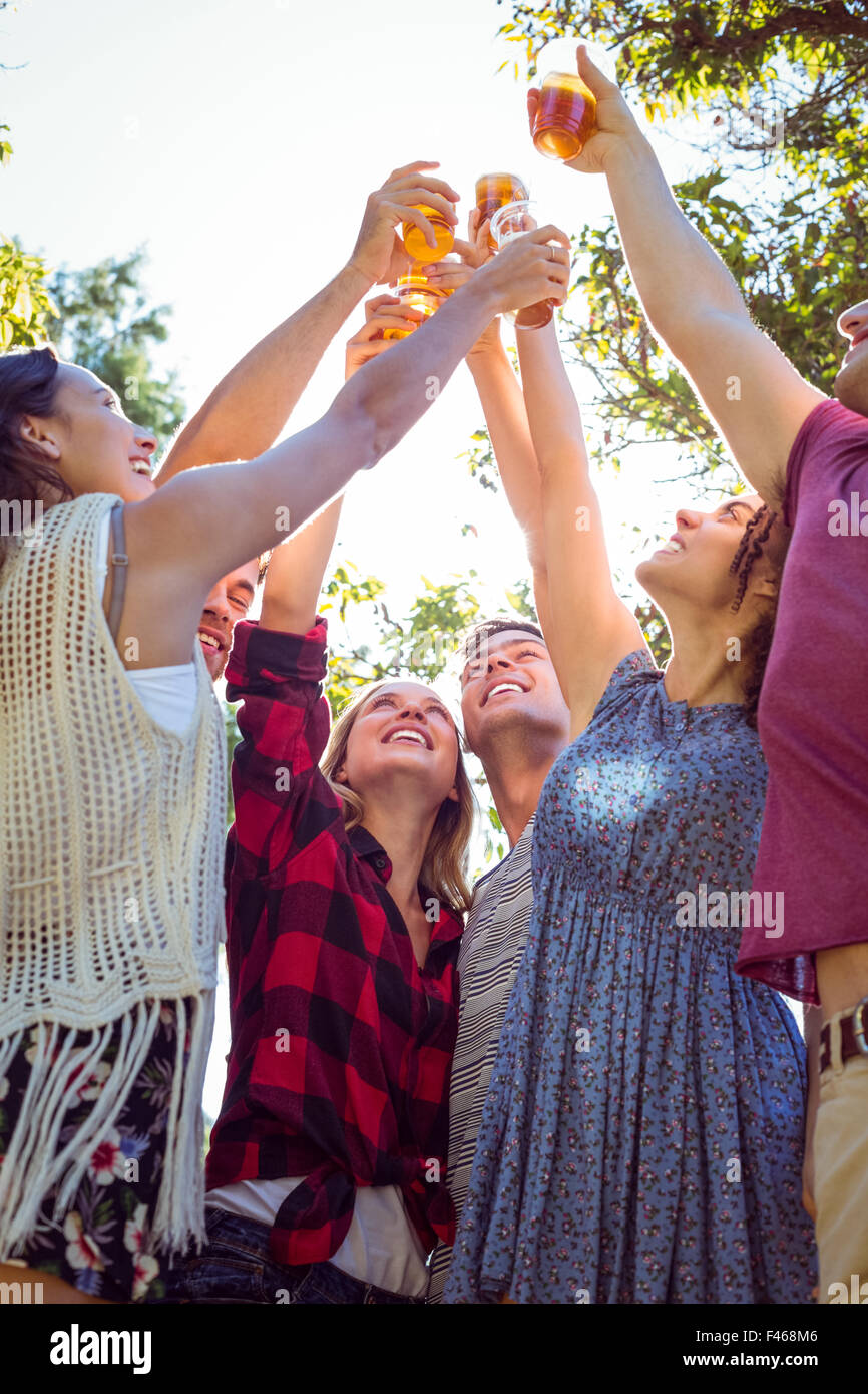 Happy friends in the park having beers Stock Photo - Alamy