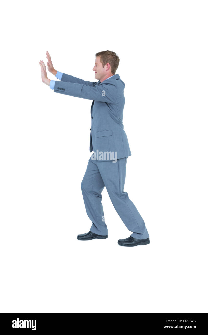 Businessman standing and pushing with hands Stock Photo - Alamy