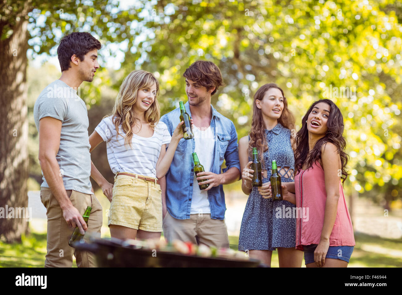 Happy friends in the park having barbecue Stock Photo - Alamy